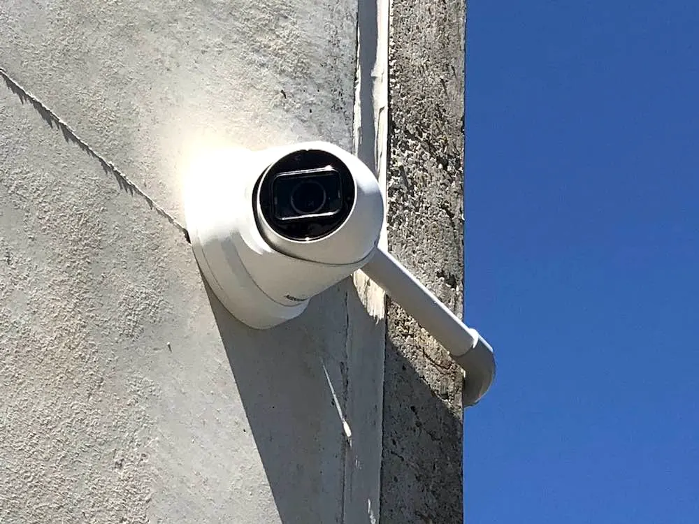 A security camera mounted on the corner of a storage building